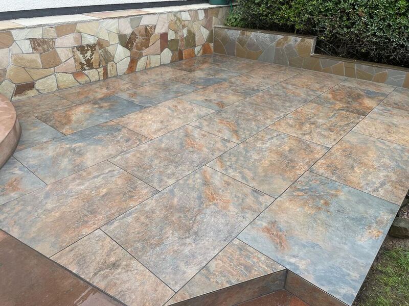 Multi-tone stone patio with crazy-paving clad wall